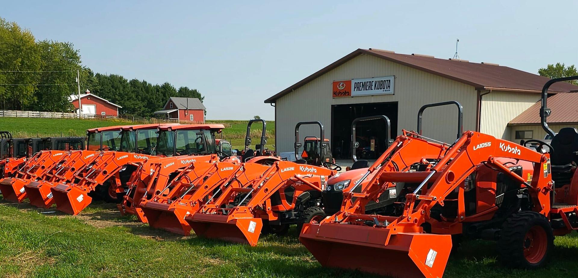 Orange Kubota Tractors in front of Kubota Dealership - Premiere Kubota of Waukon